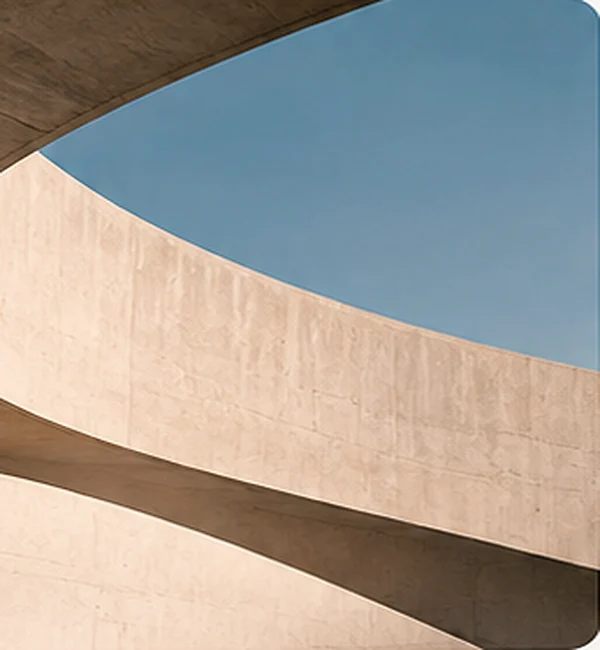 Arquitectura de concreto con formas curvas y cielo azul.