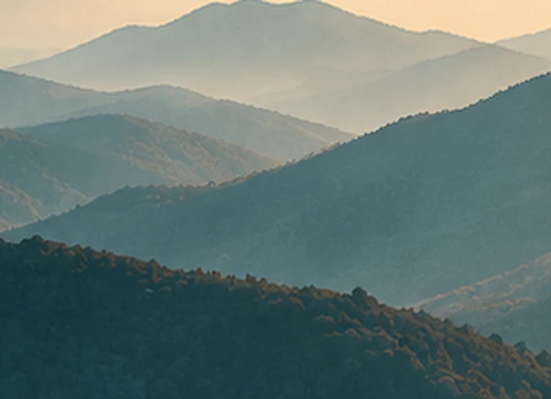 Capas de montañas bajo la luz cálida del amanecer.